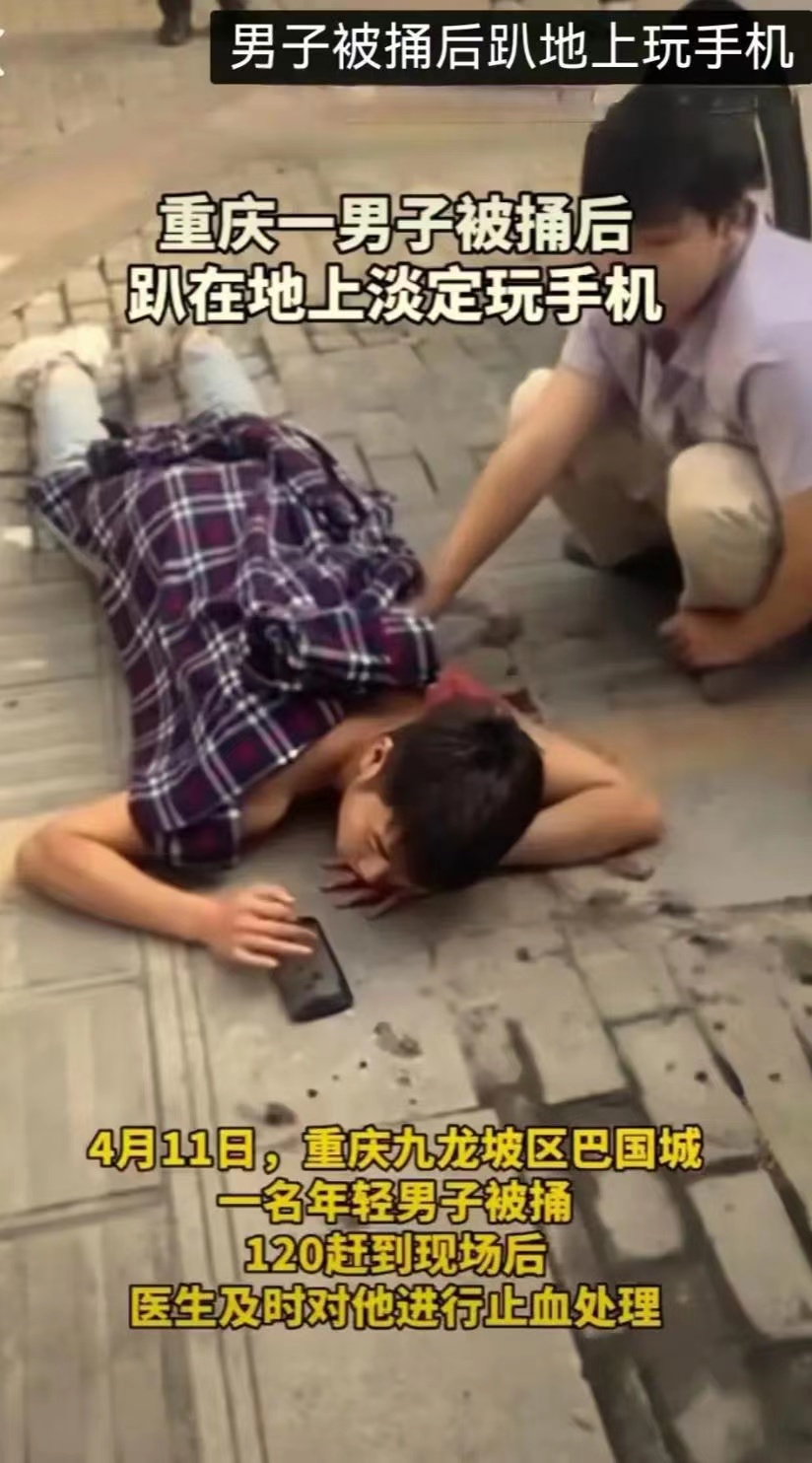 一男子背部被捅后竟趴在地上淡定玩手机